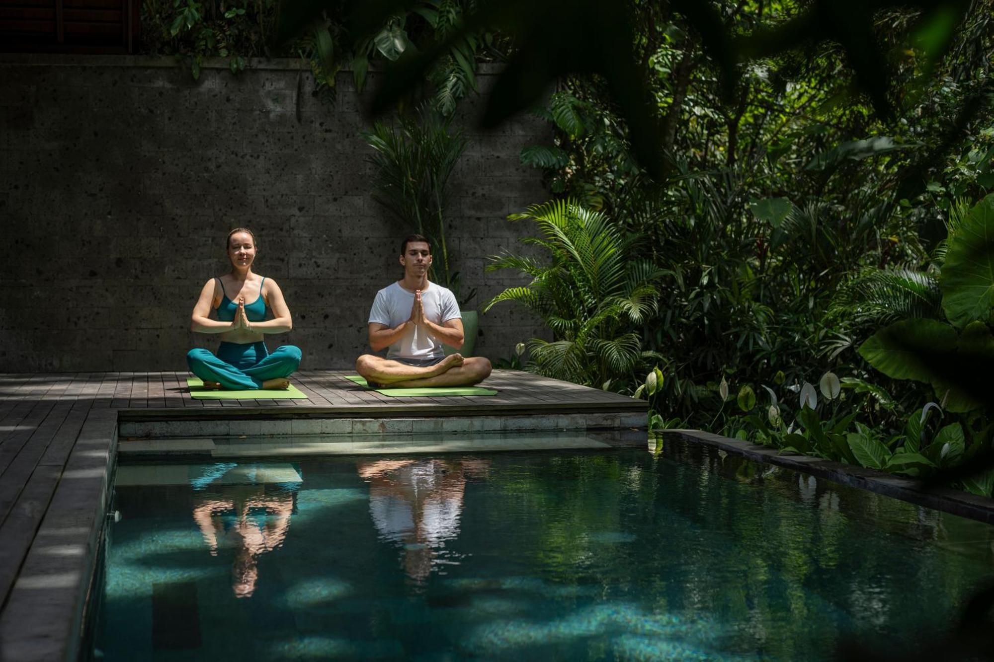 Adiwana Suweta Hotel Ubud Eksteriør billede A couple practicing yoga at the Bvlgari Spa